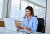Woman wearing headset working on computer in office